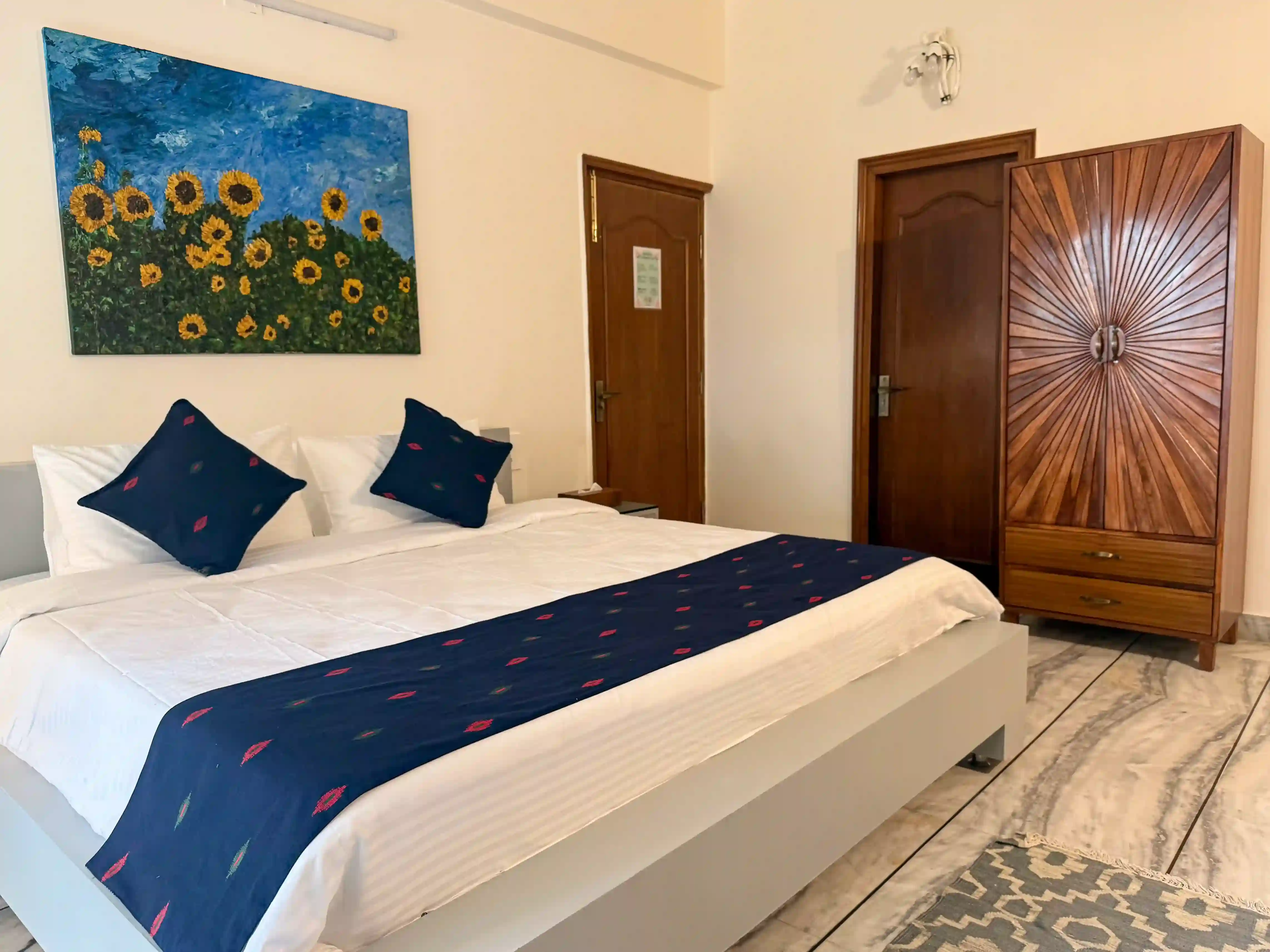 Parijat family suite at ArtRest Ahmedabad, with original sunflower artwork and a handcrafted wooden wardrobe.
